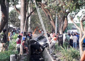 Mobil yang mengalami kecelakaan dan masuk sungai di Jalan Raya Sawojajar, Kota Malang.