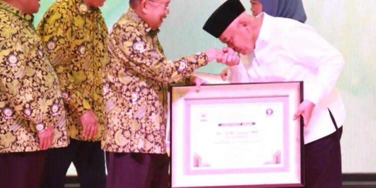 Bupati Malang, Sanusi menerima penghargaan dari Ketua Pengurus Pusat DMI, Muhammad Jusuf Kalla.