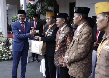 Pj Wali Kota Malang, Wahyu Hidayat, memberikan penghargaan pada orang-orang yang berjasa.
