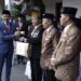 Pj Wali Kota Malang, Wahyu Hidayat, memberikan penghargaan pada orang-orang yang berjasa.