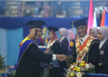 Direktur Polinem Supriatna Adhisuwigno saat mengukuhkan salah satu wisudawan terbaik.