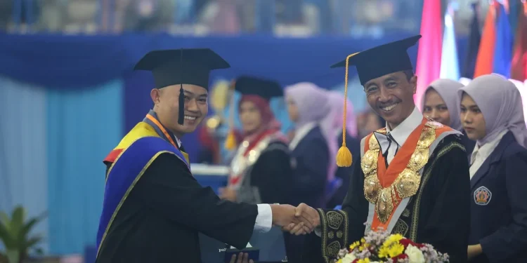Direktur Polinem Supriatna Adhisuwigno saat mengukuhkan salah satu wisudawan terbaik.