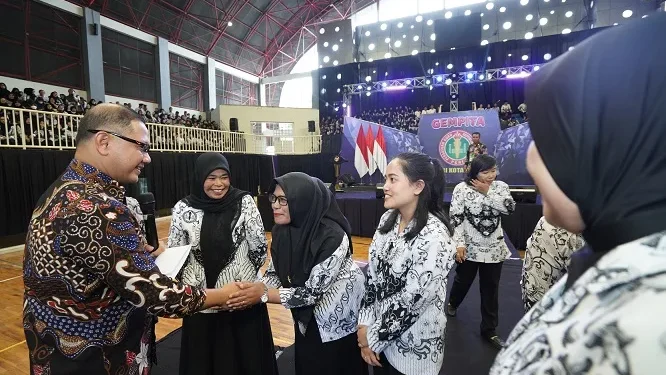 Pj Wali Kota Batu, Aries Agung Paewai, saat memberikan penghargaan terhadap para guru teladan dan berprestasi Kota Batu.