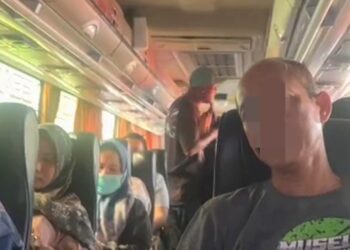 Tampak pengamen liar mengamen di dalam bus yang diisi wisatawan saat berlibur di Kota Batu, Jawa Timur.