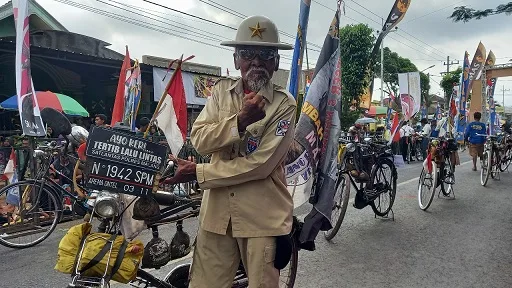 Sutikno berpose dengan sepeda onthel kesayangannya. 