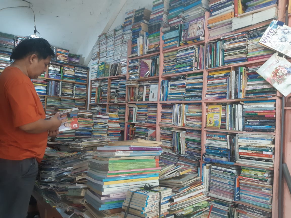 Pedagang buku di Pasar Buku Velodrom, Kota Malang menata dagangan.