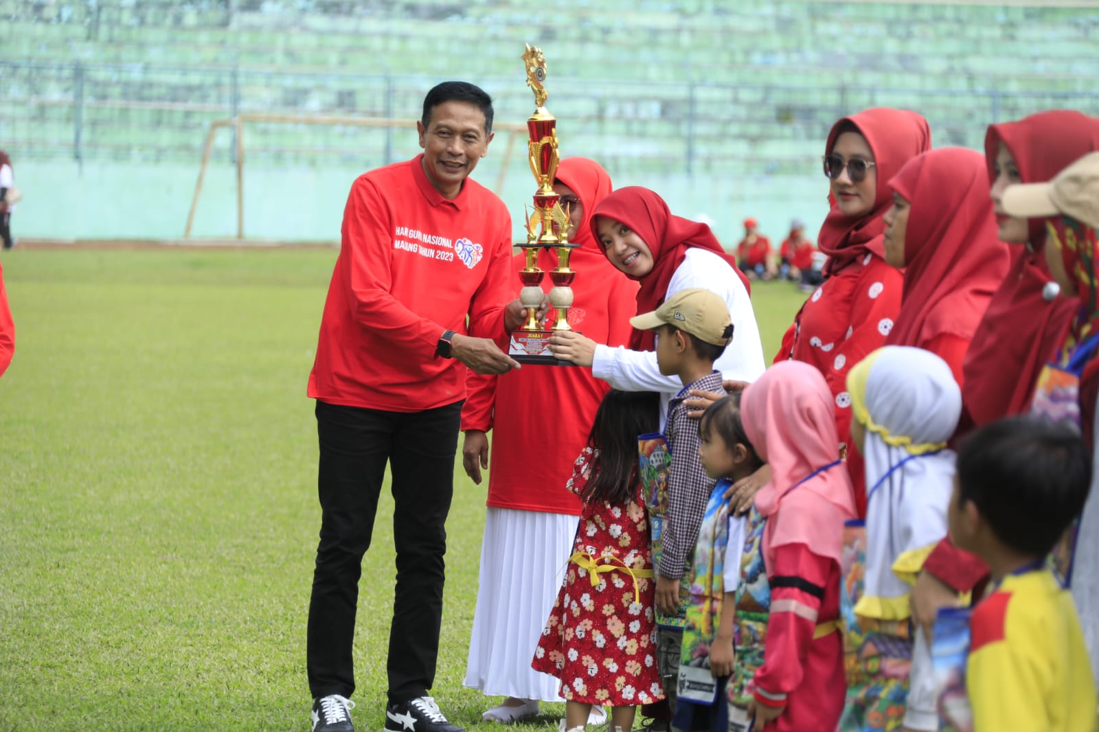 Pj Wali Kota Malang, Wahyu Hidayat, memberikan piala pada siswa.