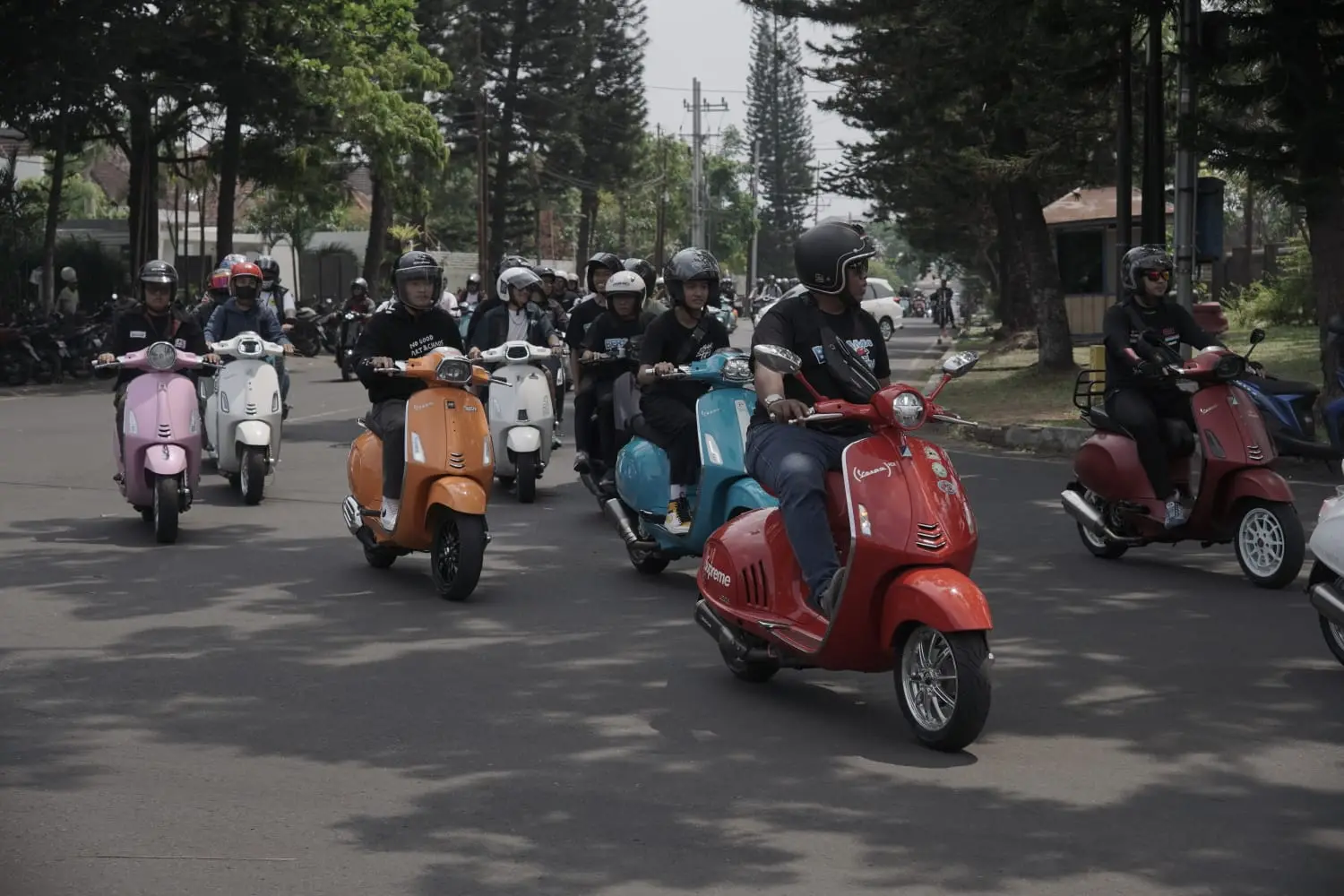 Puluhan pengendara Vespa mengelilingi jalanan di Kota Malang.
