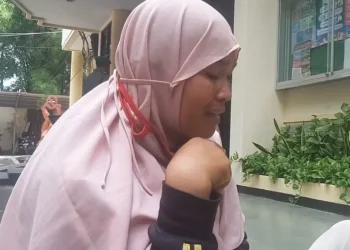 Seorang ibu menangis haru usai menerima paket sembako murah dalam program Pasar Murah di Kota Malang.