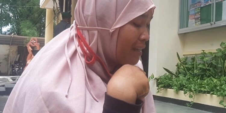 Seorang ibu menangis haru usai menerima paket sembako murah dalam program Pasar Murah di Kota Malang.