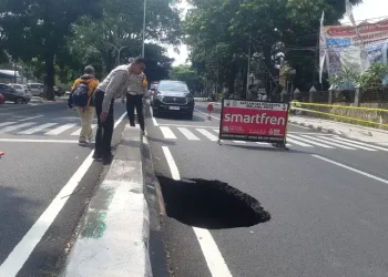 Aspal di Jalan Bandung Kota Malang ambrol.