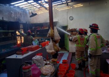 Petugas melakukan penanggulangan kebakaran di sebuah rumah di Bululawang.
