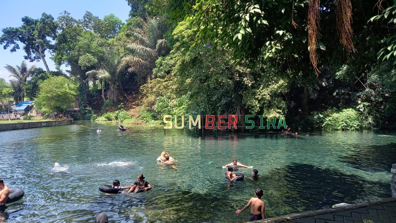 Para wisatawan menikmati aktivitas berenang di Sumber Sira.