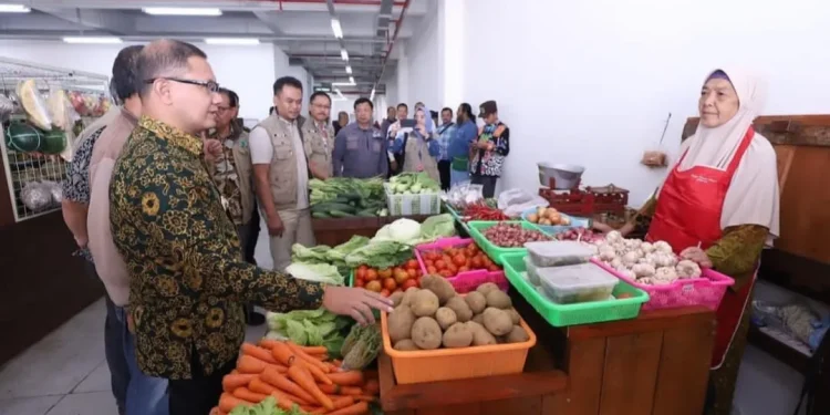 Pj Wali Kota Batu, Aries Agung Paewai, saat meninjau harga kebutuhan pokok di Pasar Induk Among Tani Kota Batu, Kamis (21/12/2023).