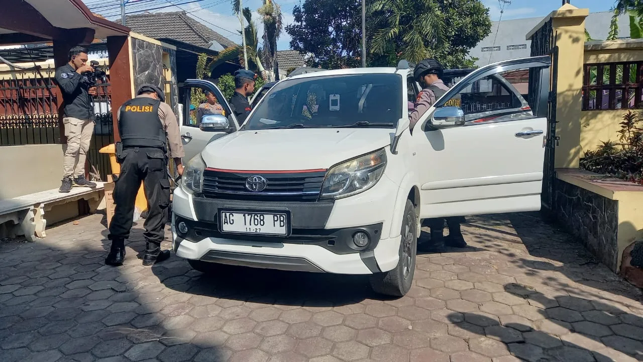 Polisi memeriksa mobil yang masuk ke area gereja.