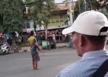 Seorang ODGJ acungkan celurit di jalanan depan Pasar Besar Kota Malang.