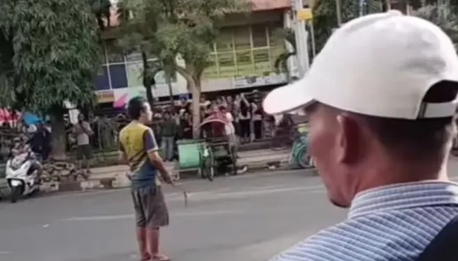 Seorang ODGJ acungkan celurit di jalanan depan Pasar Besar Kota Malang.