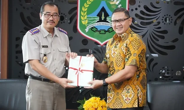Pj Wali Kota Batu, Aries Agung Paewai, menerima sertifikat tanah aset dari Kepala Kantor Pertanahan, Kresna Fitriansyah, di Ruang Kerja Wali Kota Batu, Selasa (30/1/2024).
