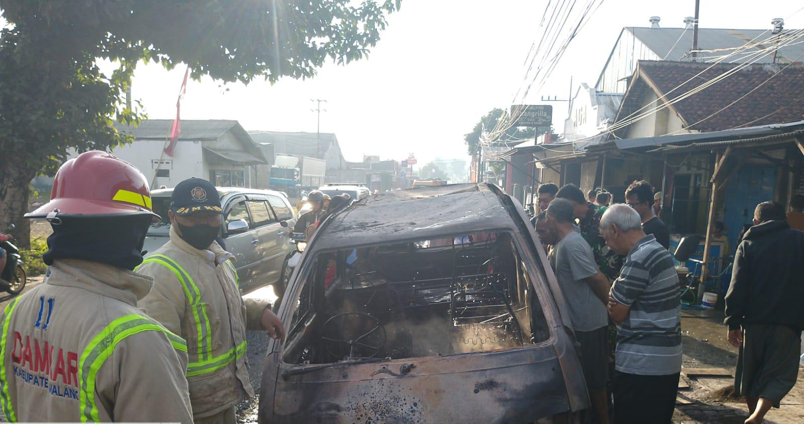 Petugas melakukan pemadaman mobil yang terbakar di Turen.