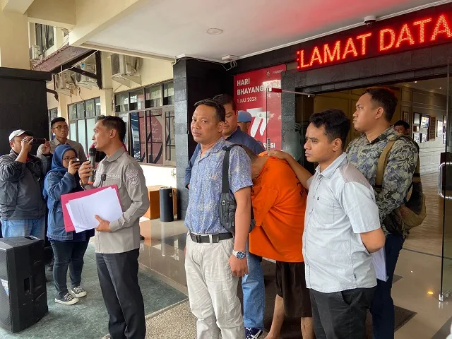 Tersangka pembunuhan dan mutilasi tertunduk di belakang kuasa hukumnya.