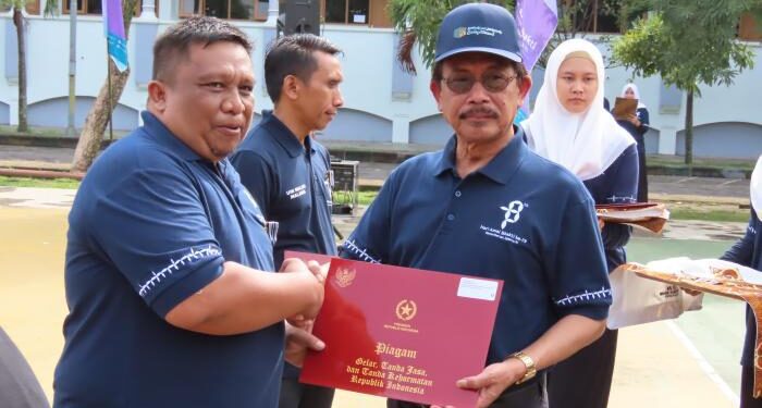Rektor UIN Malang menyerahkan apresiasi kepada salah satu pegawai.