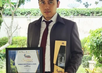Dzulfikar berfoto dengan piala dan piagam KORPRI Awards.
