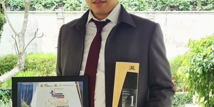 Dzulfikar berfoto dengan piala dan piagam KORPRI Awards.