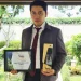 Dzulfikar berfoto dengan piala dan piagam KORPRI Awards.