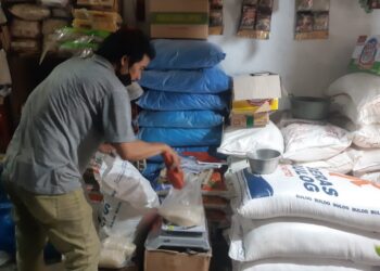 Pedagang sembako di pasar Kota Malang menimbang beras SPHP dari Bulog. (Foto/M Sholeh)