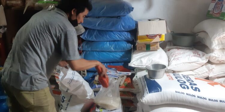 Pedagang sembako di pasar Kota Malang menimbang beras SPHP dari Bulog. (Foto/M Sholeh)