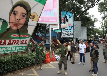 Pj Wali Kota Malang, Dr. Ir. Wahyu Hidayat, MM, saat ikut menertibkan APK di masa tenang kampanye.