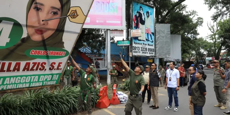 Pj Wali Kota Malang, Dr. Ir. Wahyu Hidayat, MM, saat ikut menertibkan APK di masa tenang kampanye.