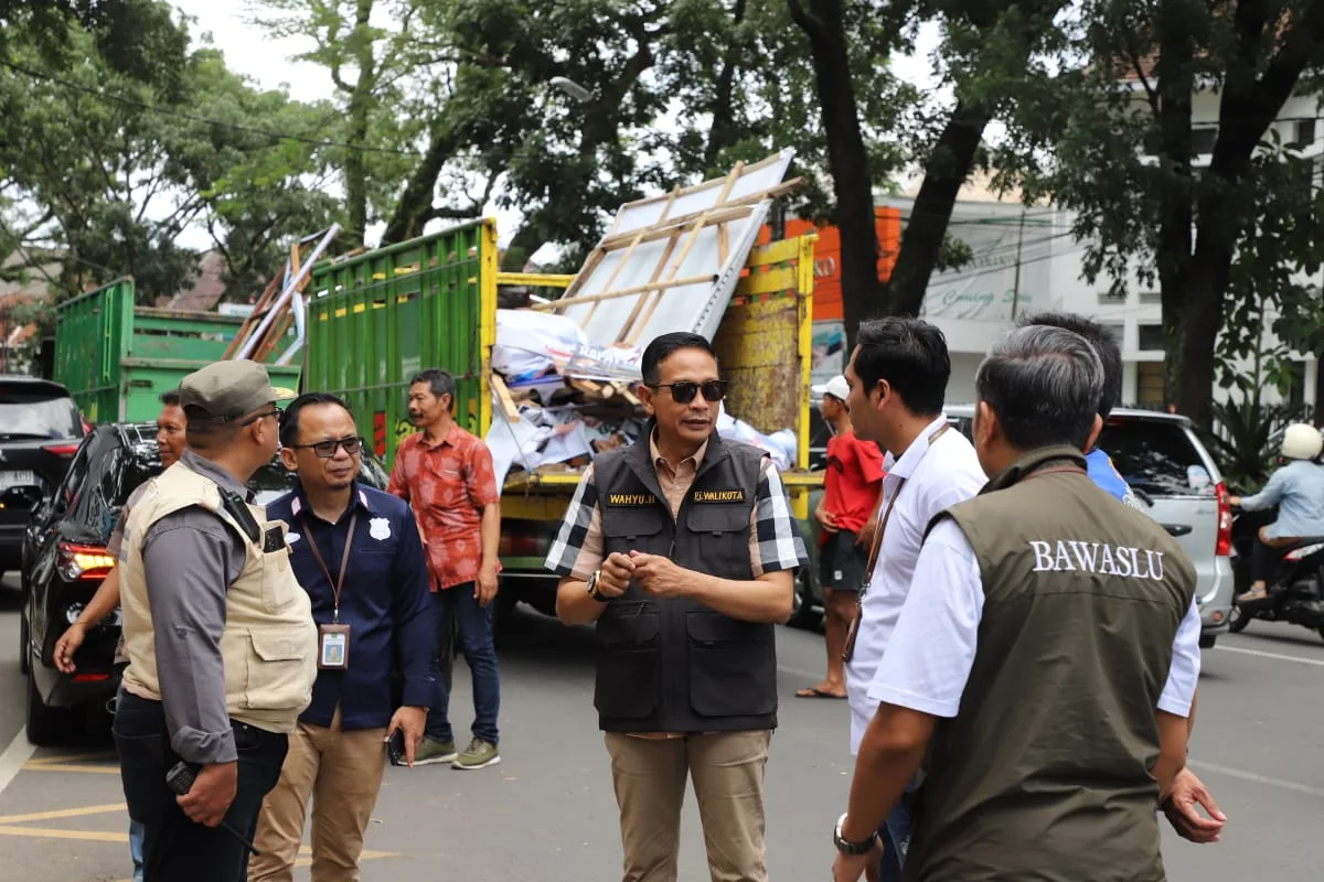 Pj Wali Kota Malang, Dr. Ir. Wahyu Hidayat, MM, saat ikut menertibkan APK di masa tenang kampanye. 