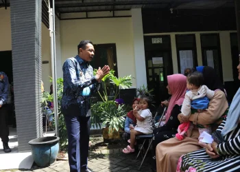 Pj Wali Kota Malang meninjau penyerahan bantuan pangan di kantor kelurahan buring.