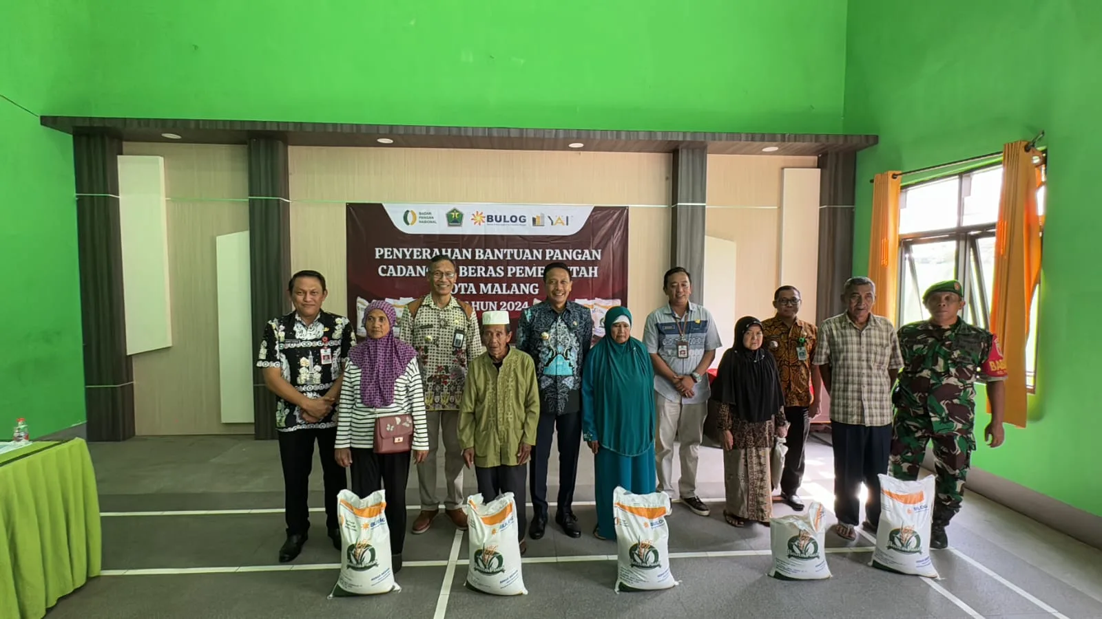 Pj Wali Kota Malang meninjau penyerahan bantuan pangan di kantor kelurahan buring.