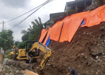 Proses normalisasi saluran irigasi di Sukun yang tertimbun material plengsengan yang longsor. (Foto/M Sholeh)