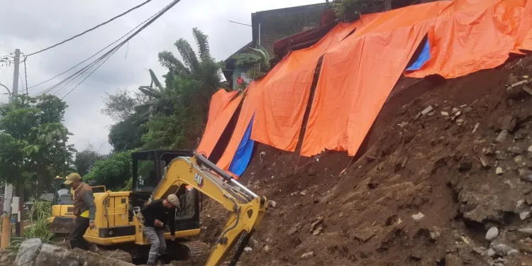 Proses normalisasi saluran irigasi di Sukun yang tertimbun material plengsengan yang longsor. (Foto/M Sholeh)