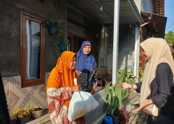 Respon antusias warna menerima paket sembako yang dibagikan oleh mahasiswa Fakultas Vokasi UMM. Foto / dok