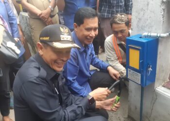 Pj Wali Kota Malang, Wahyu Hidayat meresmikan dan mengoperasikan sambungan atau meteran baru untuk warga di Jalan Muharto, Kota Malang. (Foto/M Sholeh)