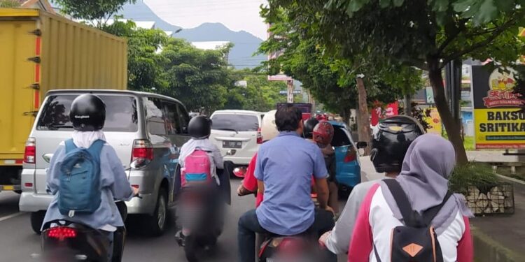 Ilustrasi pengendara di Kota Batu, Jawa Timur tidak mengenakan helm saat berkendara. Foto: Azmy