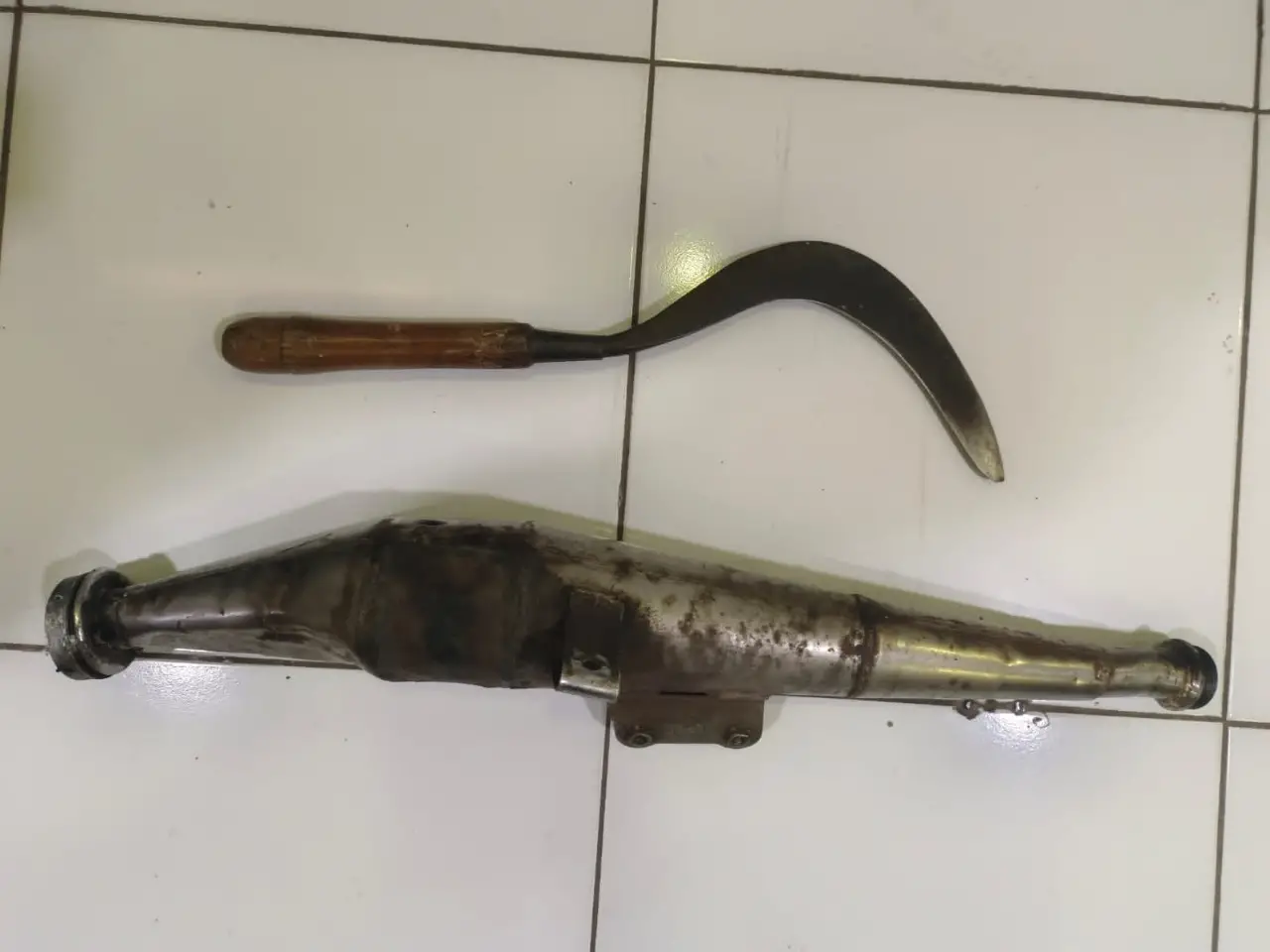 Barang bukti knalpot dan clurit yang diamankan polisi. Foto: Polres Malang
