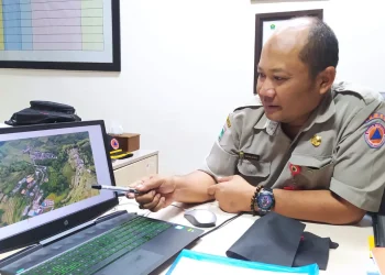 Kepala BPBD Kota Batu, Agung Sedayu, menunjukkan opsi lahan untuk relokasi yang aman di 4 titik di Dusun Brau. Ini solusi bagi dampak tanah bergerak. Foto; Azmy
