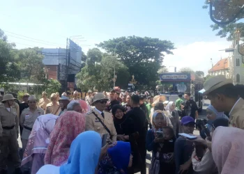 Pj Wali Kota Malang, Wahyu Hidayat berfoto bersama emak emak saat memimpin pawai di kawasan Kayutangan. (Foto/M Sholeh)