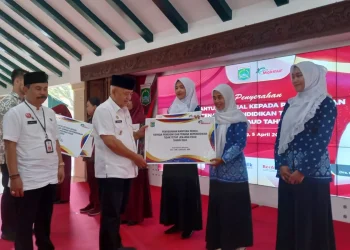 Bupati Malang, Sanusi menyerahkan insentif secara simbolis kepada guru dan tenaga kependidikan non ASN. Pemkab Malang gelontokan miliaran rupiah untuk insentif guru. Foto: Aisyah Nawangsari Putri
