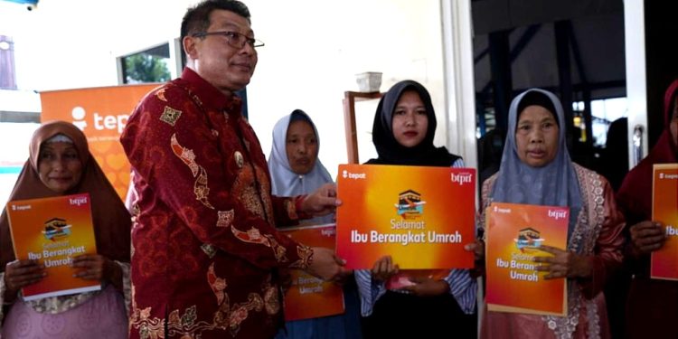 Wabup Malang Didik Gatot Subroto memberikan secara simbolis hadiah umrah satu pesawat kepada warga kumpulan nasabah BTPN Syariah. Foto: Azmy