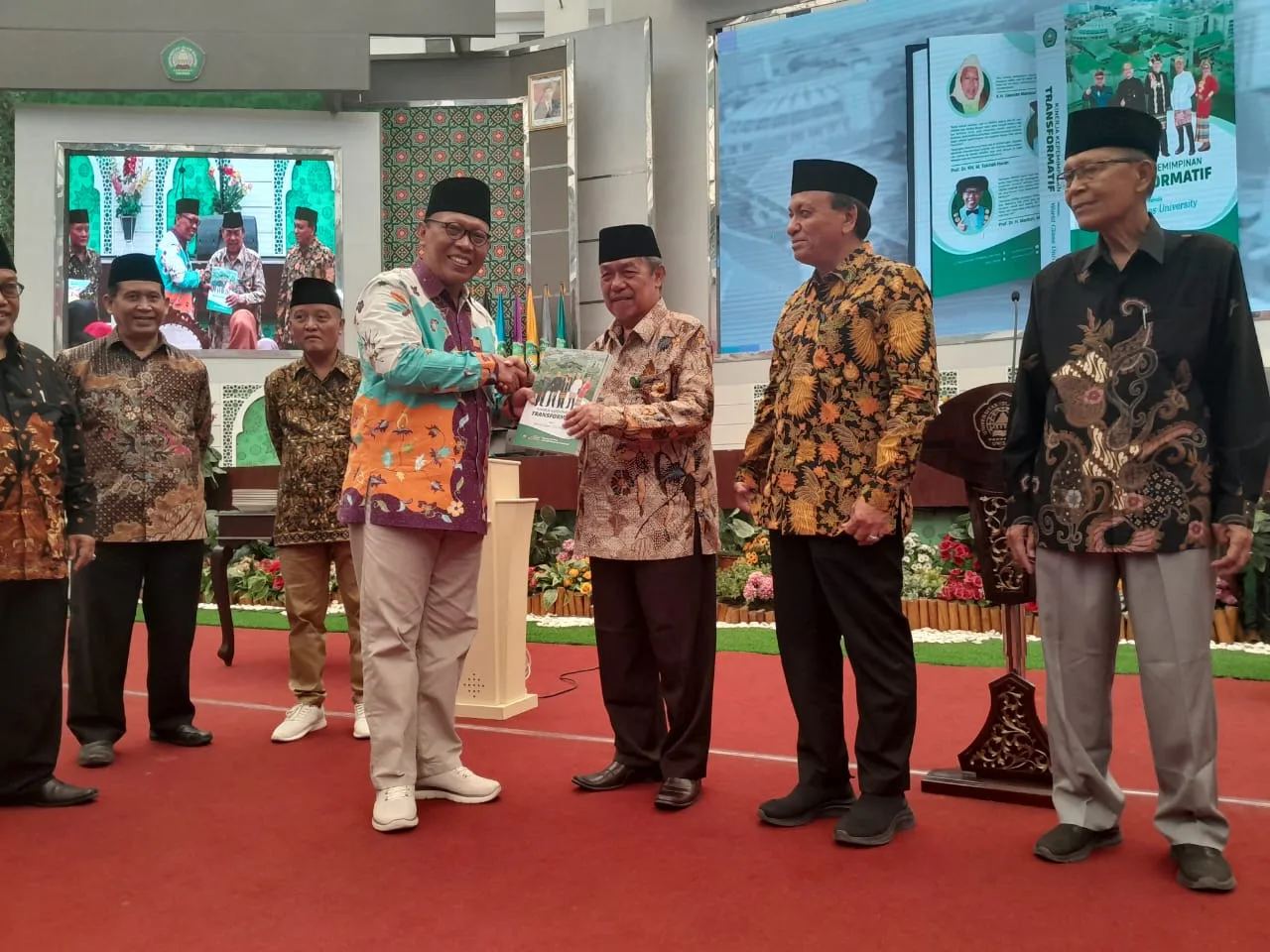 Rektor Unisma, Prof. Maskuri menyerahkan buku Kinerja Kepemimpinan Transformatif Menuju World Class University kepada pihak yayasan/Foto: Tugumalang.id/Bagus Rachmad Saputra.