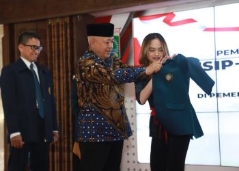 Bupati Malang, Sanusi, memakaian jas almamater pada mahasiswa sebagai simbol dibukanya program Mahasiswa Membangun Desa. Foto: Pemkab Malang