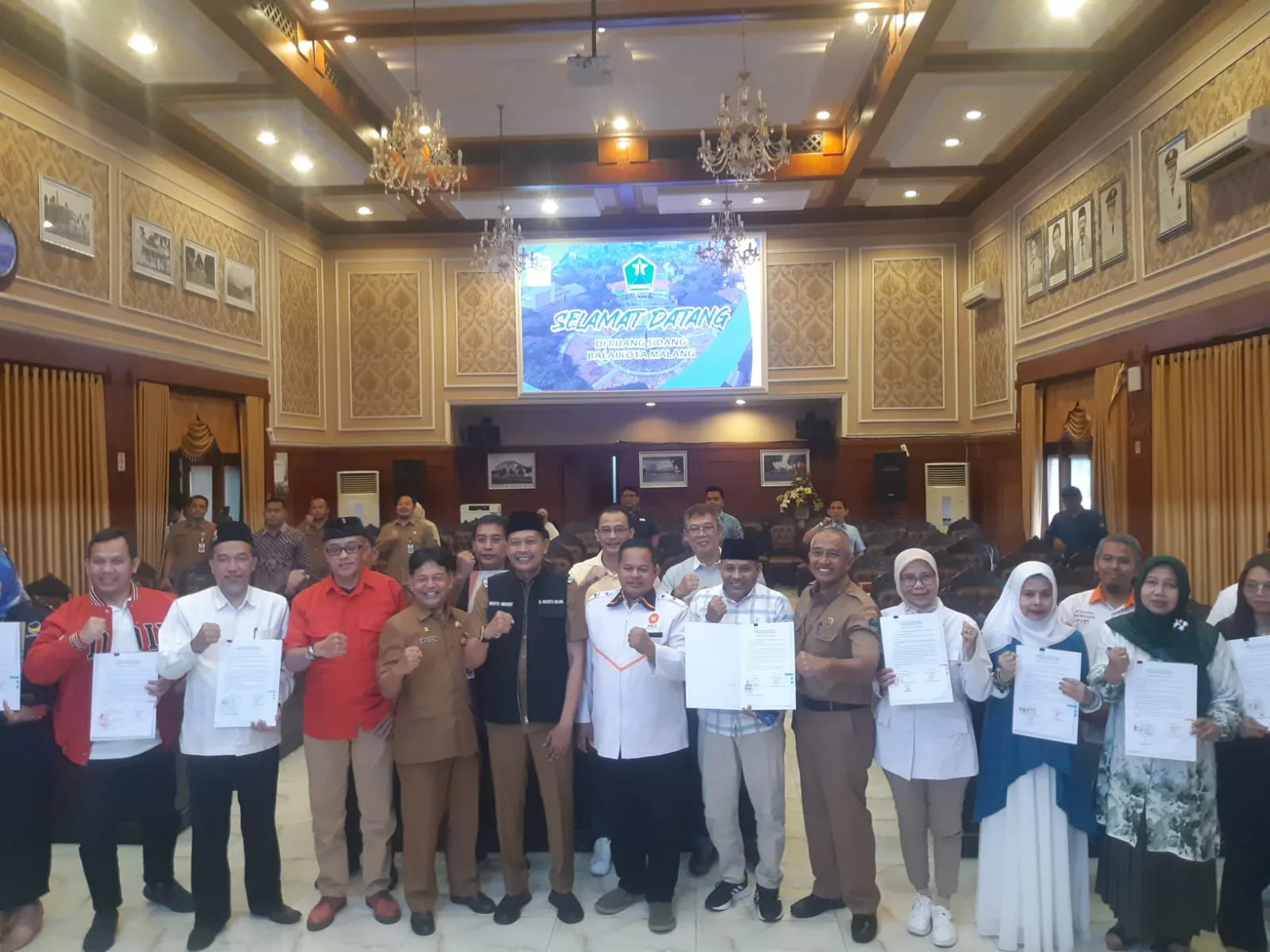 Foto bersama setelah Pj Wali Kota Malang, Wahtu Hidayat, menyerahkan bantuan keuangan partai politik periode hasil Pemilu 2019-2024. (Foto/M Sholeh)