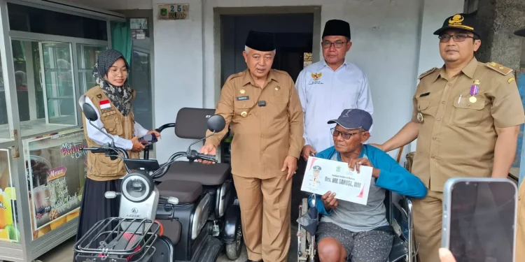 Bupati Malang, Sanusi menyerahkan bantuan sepeda listrik kepada penyandang disabilitas. Foto: Aisyah Nawangsari Putri