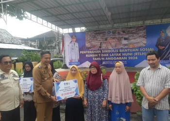 Pj Wali Kota Malang, Wahyu Hidayat menyerahkan secara simbolis bantuan bedah rumah kepada warga Kelurahan Tulusrejo. (Foto/M Sholeh)